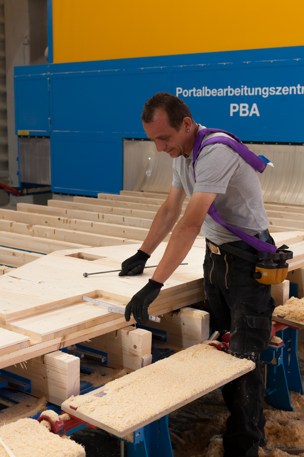 Mitarbeiter an Massivholzwand